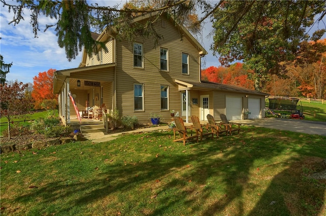 view of front facade featuring covered porch, a garage, and a front lawn