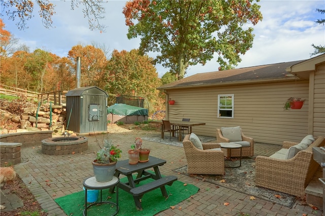 view of patio with an outdoor fire pit and a shed