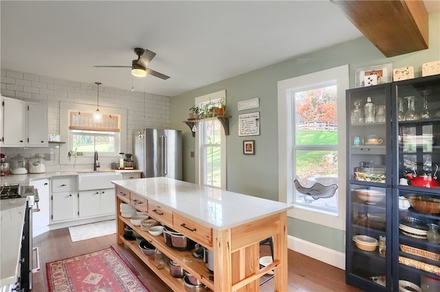 kitchen featuring appliances with stainless steel finishes, white cabinetry, a healthy amount of sunlight, and dark hardwood / wood-style floors