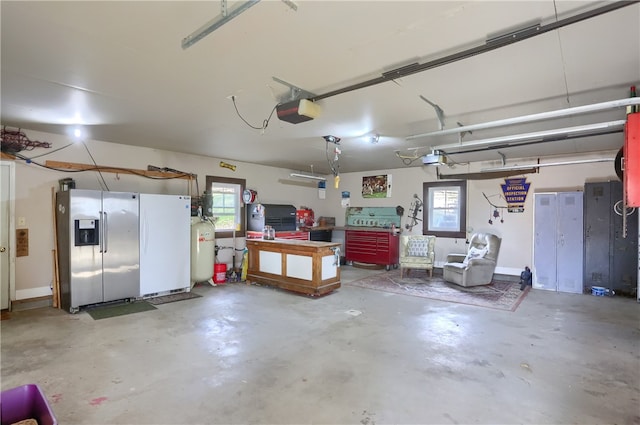 garage featuring a workshop area, a garage door opener, and stainless steel fridge