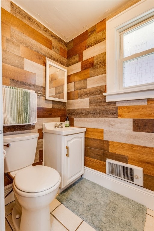 bathroom with vanity, wooden walls, and toilet