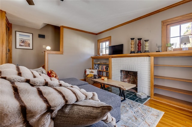 bedroom featuring a brick fireplace, ornamental molding, wood-type flooring, and multiple windows