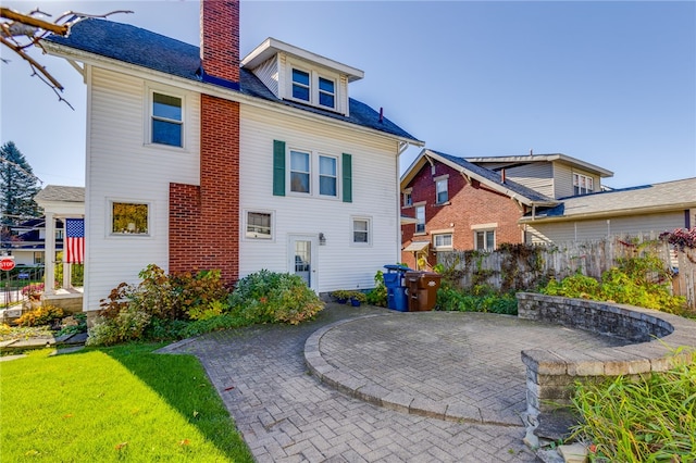 rear view of property with a yard and a patio area