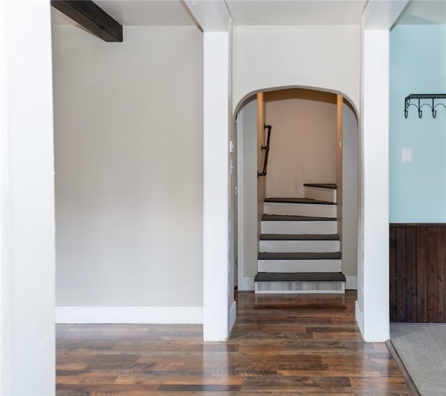 staircase featuring hardwood / wood-style floors and beam ceiling