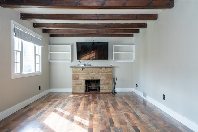 unfurnished living room with a stone fireplace, dark hardwood / wood-style floors, and beamed ceiling