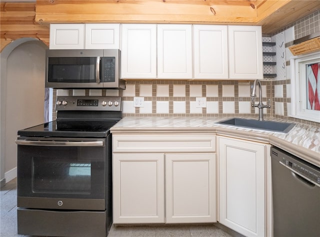 kitchen with appliances with stainless steel finishes, sink, and white cabinets