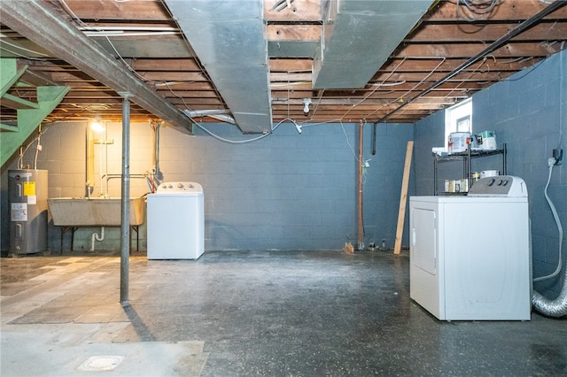 basement featuring electric water heater, sink, and separate washer and dryer