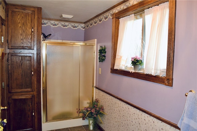 bathroom with walk in shower and ornamental molding