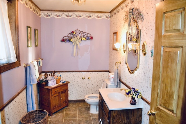 bathroom featuring vanity, toilet, crown molding, and tile patterned floors