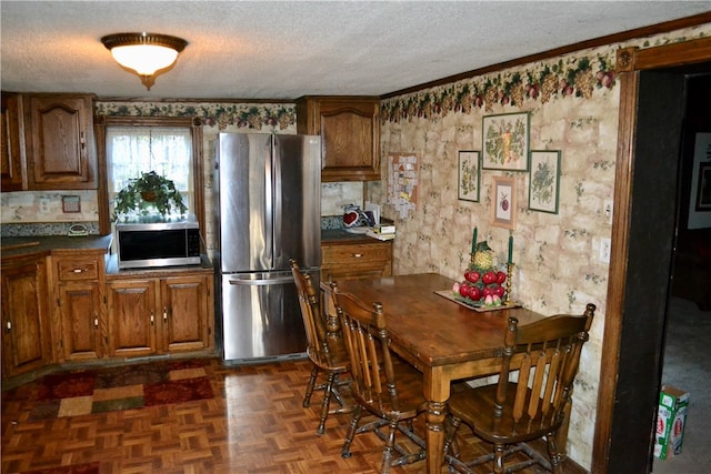 dining room featuring ornamental molding, a textured ceiling, and dark parquet floors