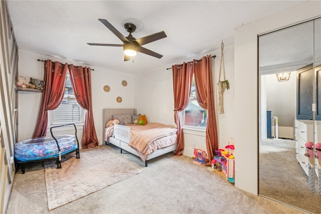 bedroom with a closet, ceiling fan, multiple windows, and light colored carpet