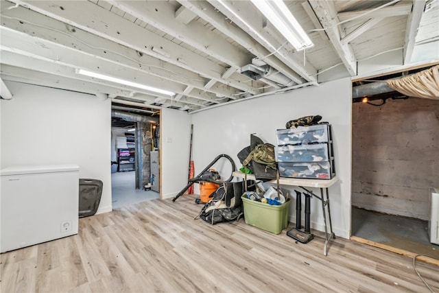 basement with refrigerator and light hardwood / wood-style flooring