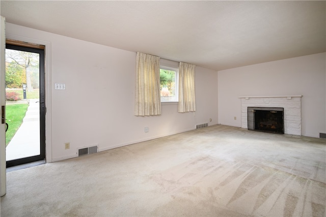 unfurnished living room featuring light carpet and a wealth of natural light