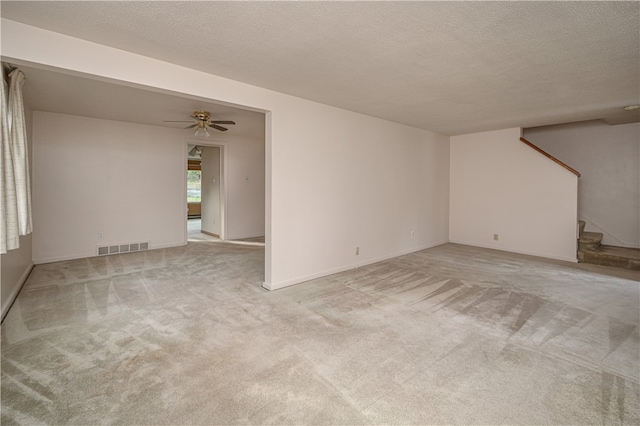 unfurnished living room featuring a textured ceiling, light colored carpet, and ceiling fan