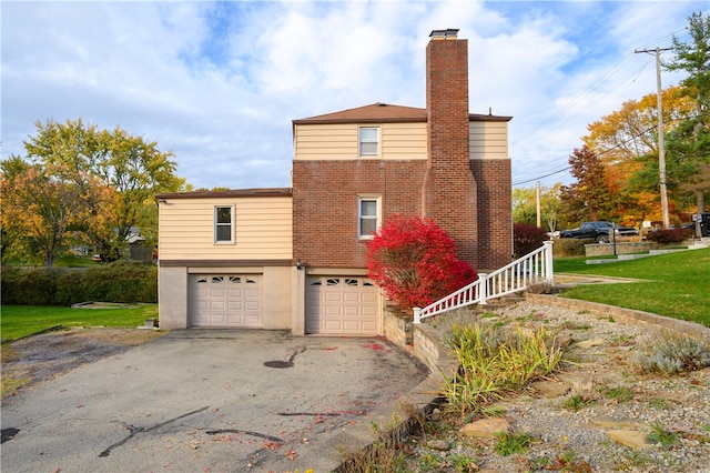 view of home's exterior with a garage and a lawn