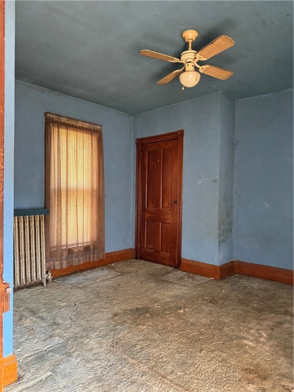 empty room with radiator and ceiling fan