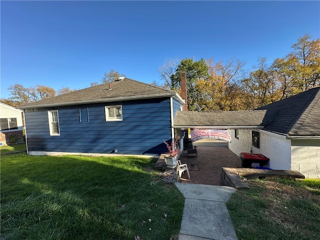 view of property exterior with a patio and a lawn