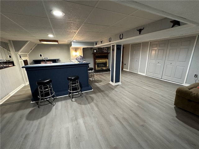 bar with wood-type flooring and a paneled ceiling