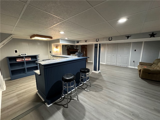 bar featuring a drop ceiling and hardwood / wood-style flooring