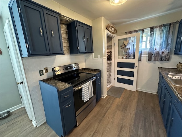 kitchen with sink, blue cabinets, stainless steel range with electric cooktop, tile walls, and dark hardwood / wood-style flooring