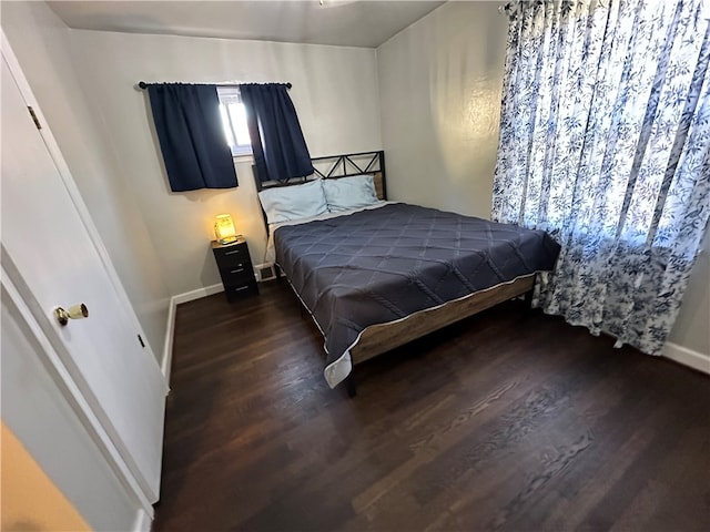 bedroom with dark hardwood / wood-style flooring