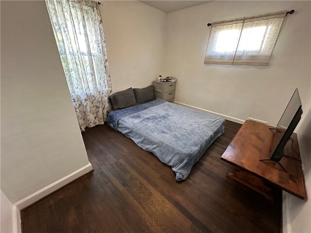 bedroom with dark hardwood / wood-style floors