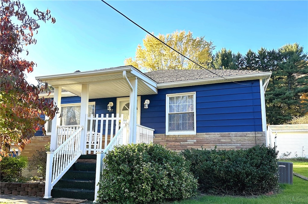 view of front of property with a porch and central AC unit