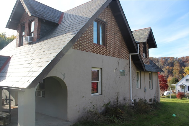 view of side of property with a patio and a lawn