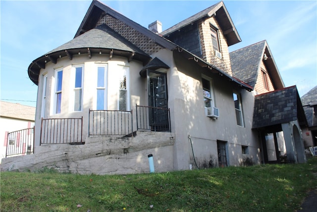 view of side of home featuring cooling unit and a lawn