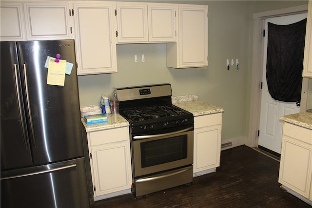 kitchen with appliances with stainless steel finishes, white cabinetry, and dark hardwood / wood-style flooring