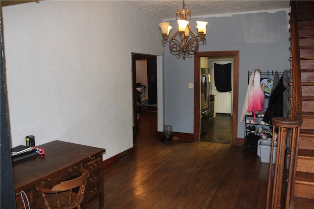 interior space with dark wood-type flooring, a textured ceiling, and a chandelier