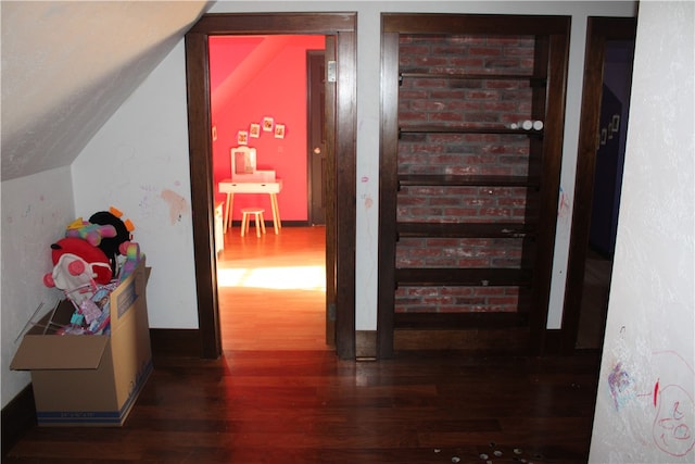 hallway featuring lofted ceiling and dark hardwood / wood-style flooring