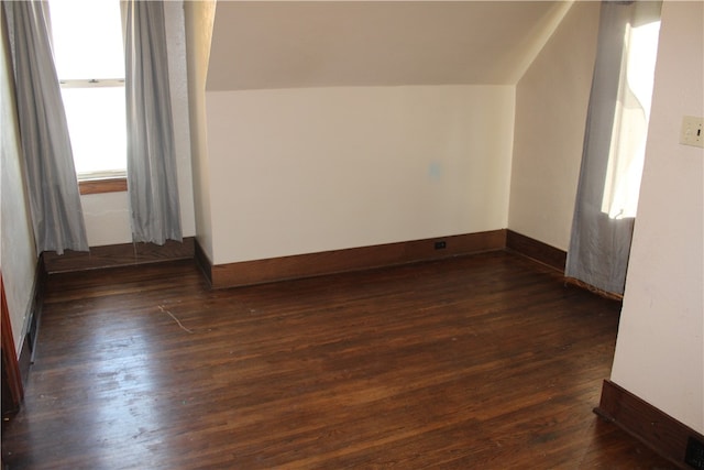 bonus room with dark hardwood / wood-style flooring and vaulted ceiling