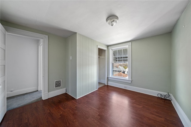 unfurnished bedroom featuring a closet and dark hardwood / wood-style floors