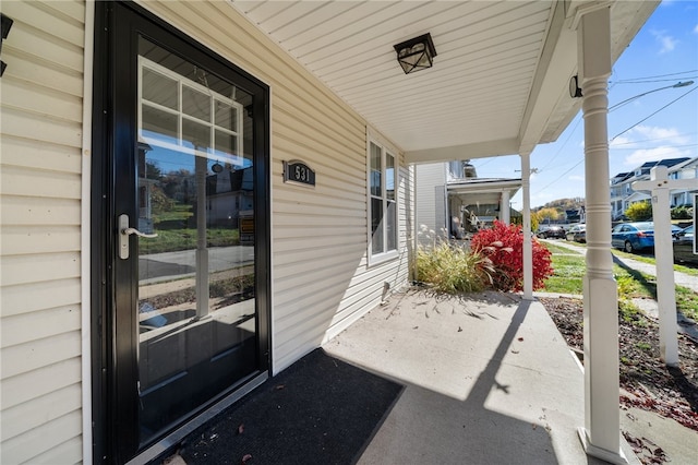 view of exterior entry featuring covered porch