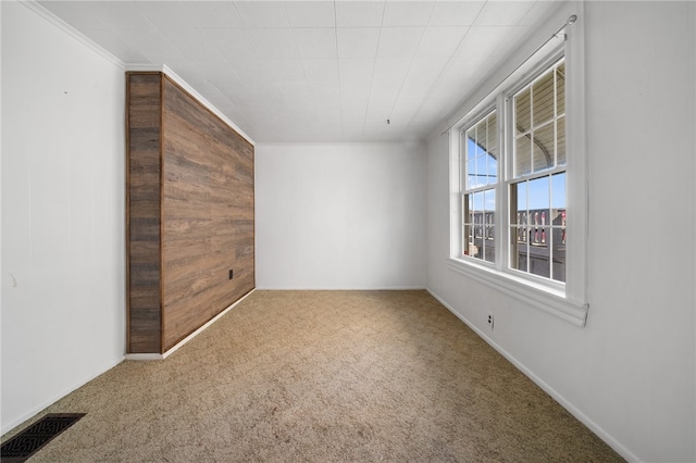 carpeted spare room featuring crown molding