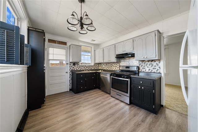 kitchen featuring stainless steel appliances, sink, ornamental molding, backsplash, and light wood-type flooring