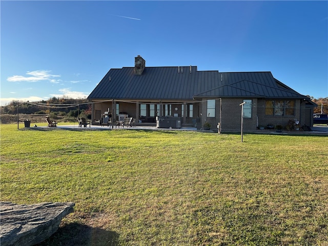 back of house featuring a patio and a lawn