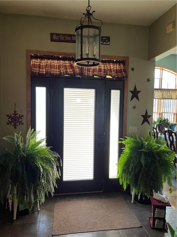 tiled foyer entrance with a notable chandelier