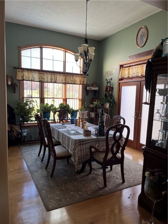 dining room featuring french doors, an inviting chandelier, and hardwood / wood-style floors