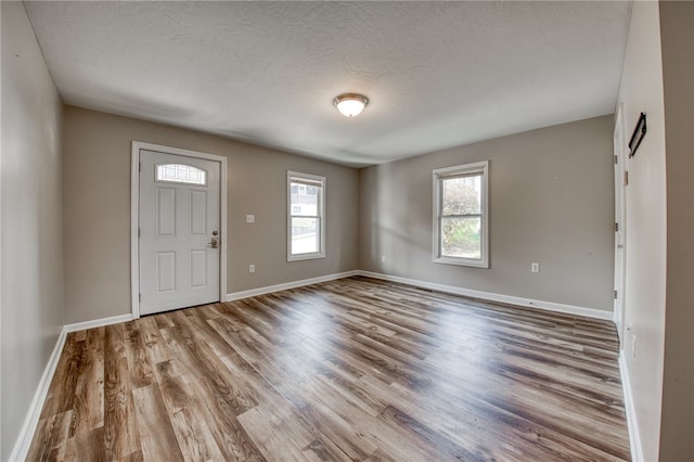 foyer with light hardwood / wood-style flooring and a textured ceiling