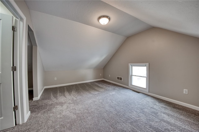 bonus room featuring a textured ceiling, vaulted ceiling, and carpet floors