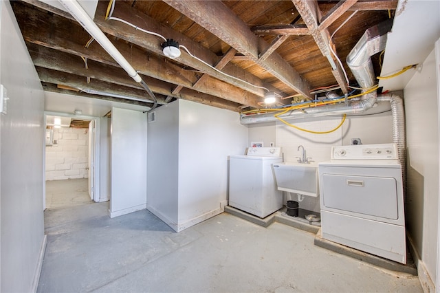 basement featuring independent washer and dryer and sink