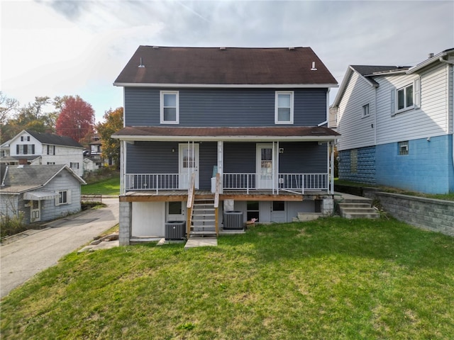 rear view of house with a porch, central AC, and a lawn