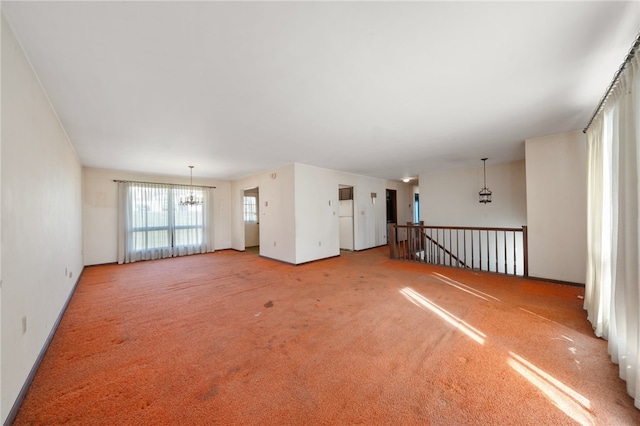 unfurnished living room featuring light carpet and a notable chandelier