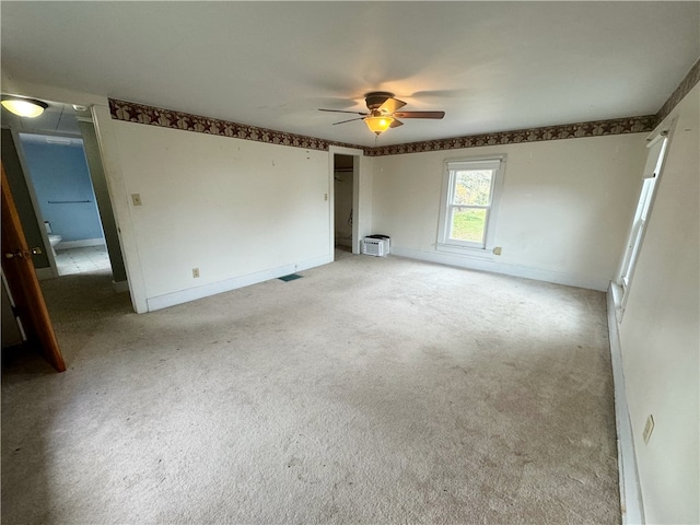 spare room with ceiling fan and light colored carpet