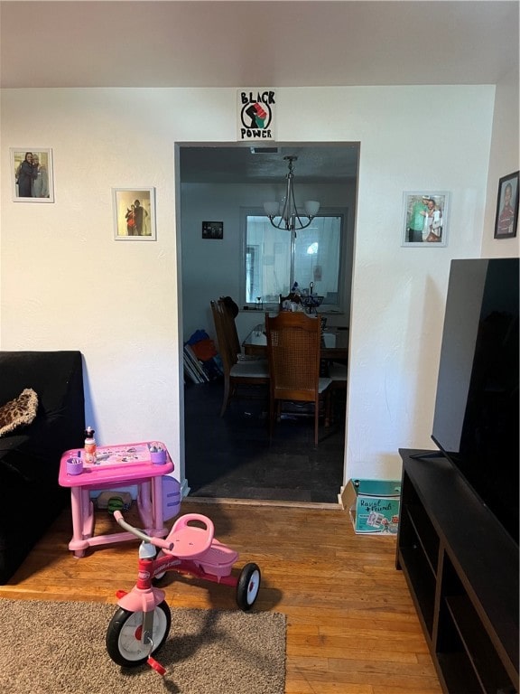 rec room with a notable chandelier and hardwood / wood-style flooring