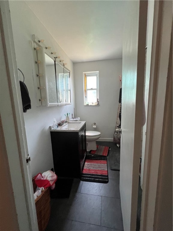 bathroom featuring vanity, toilet, and tile patterned flooring