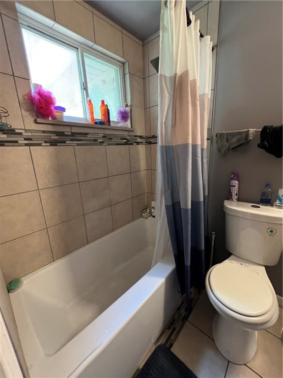 bathroom featuring tile patterned floors, shower / bath combination with curtain, and toilet