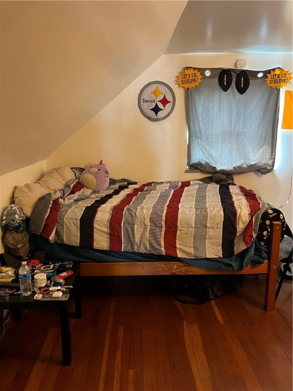 bedroom with vaulted ceiling and hardwood / wood-style floors